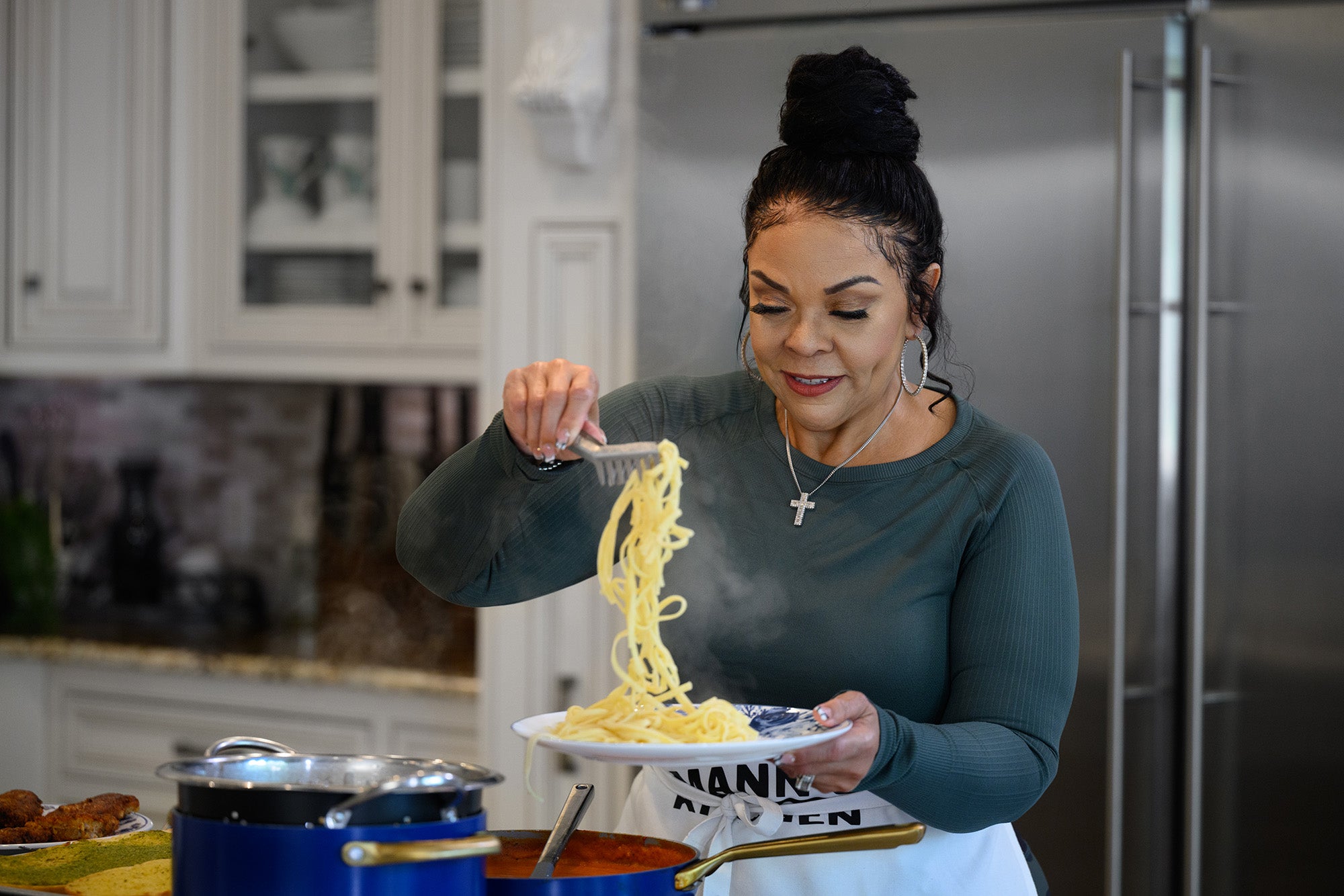 Tamela Mann serving pasta in a kitchen