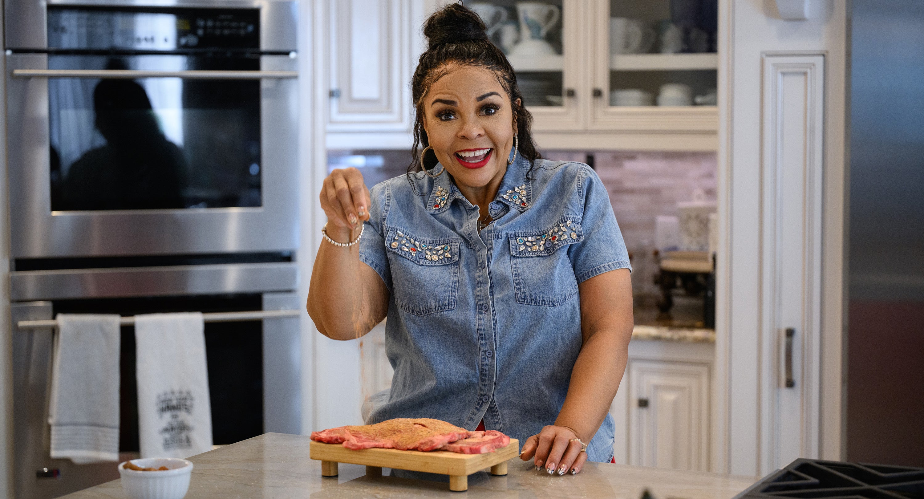 Tamela Mann in a kitchen preparing food on a cutting board